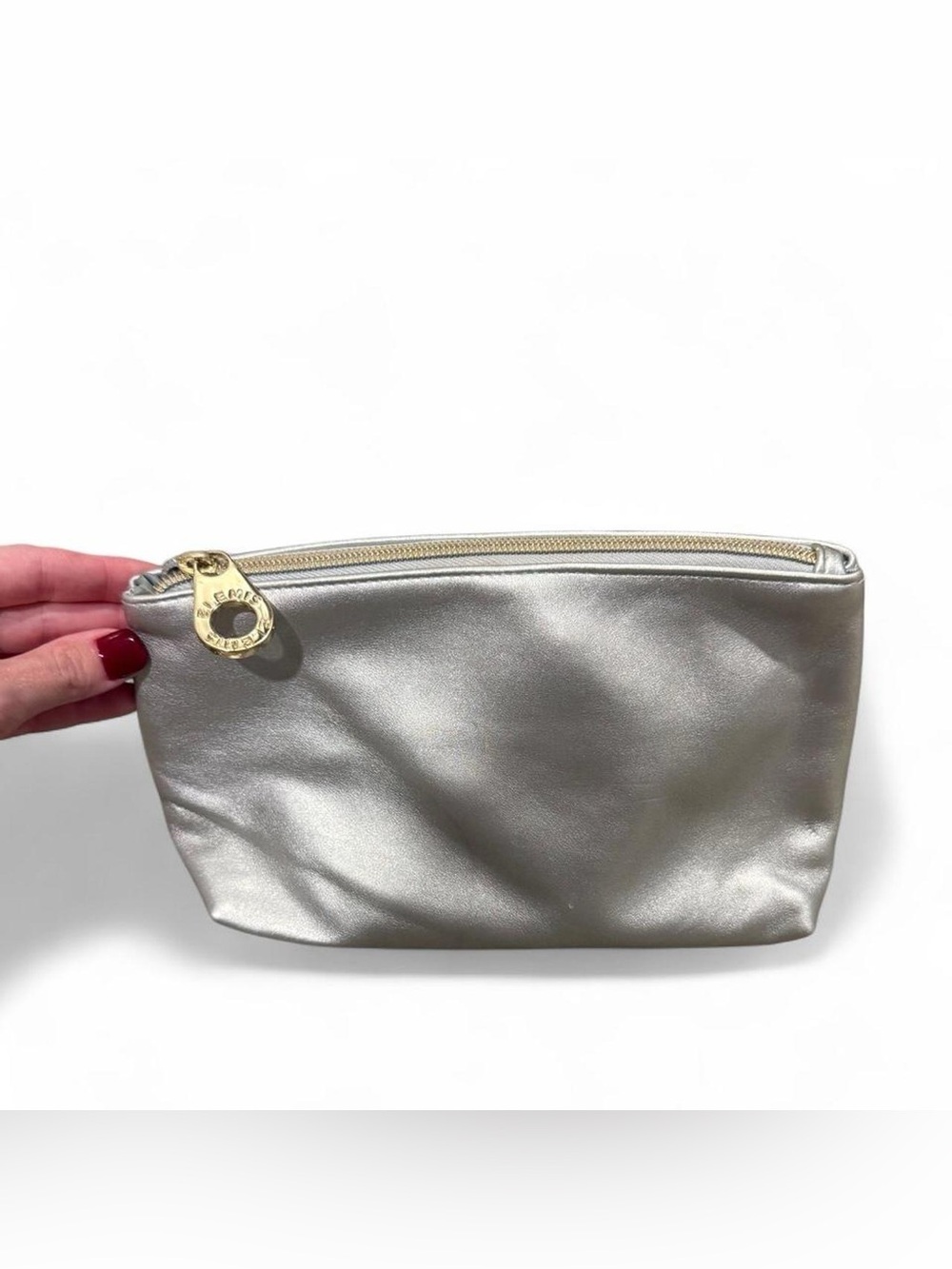 Silver Elemis metallic makeup pouch with gold zipper.